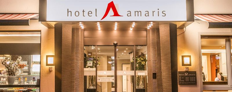 Abendliche Außenansicht des Hotel Amaris mit erleuchteter Fassade.