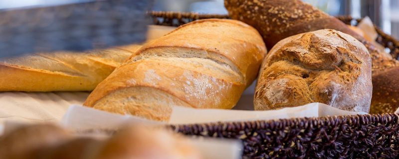 Auswahl an frischen Broten und Baguettes im Korb am Frühstücksbuffet.