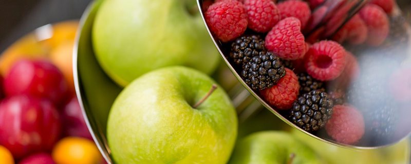 Frische grüne Äpfel und Beeren in einer Etagere am Frühstücksbuffet.
