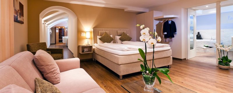 Geräumige Spa Suite im Hotel Amaris mit Schlafbereich, Wohnbereich und Zugang zum privaten Wellnessbad.