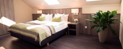 Helles AG Zimmer im Hotel Amaris mit großem Bett und Dachfenstern für viel Tageslicht.