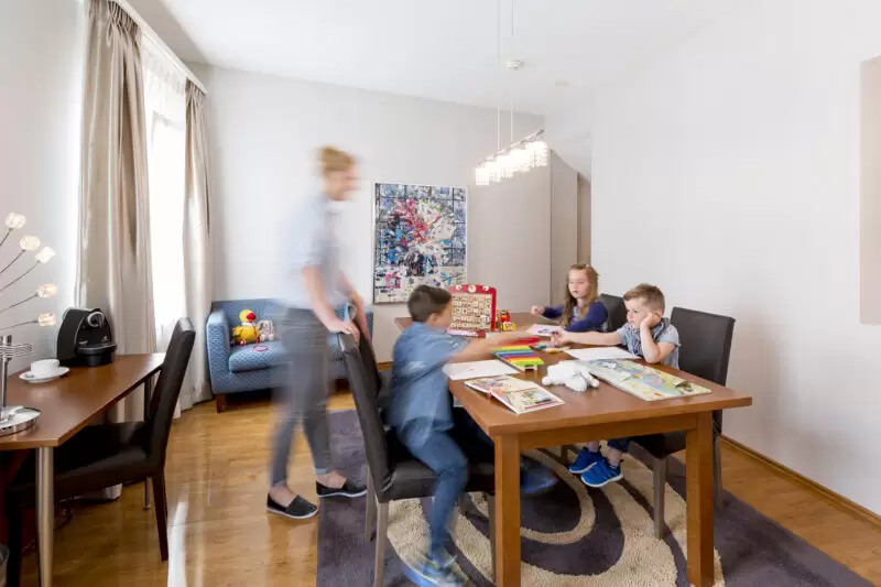 Familienzimmer im Hotel Amaris mit Kindern beim Spielen am Tisch und viel Platz für gemeinsame Aktivitäten.