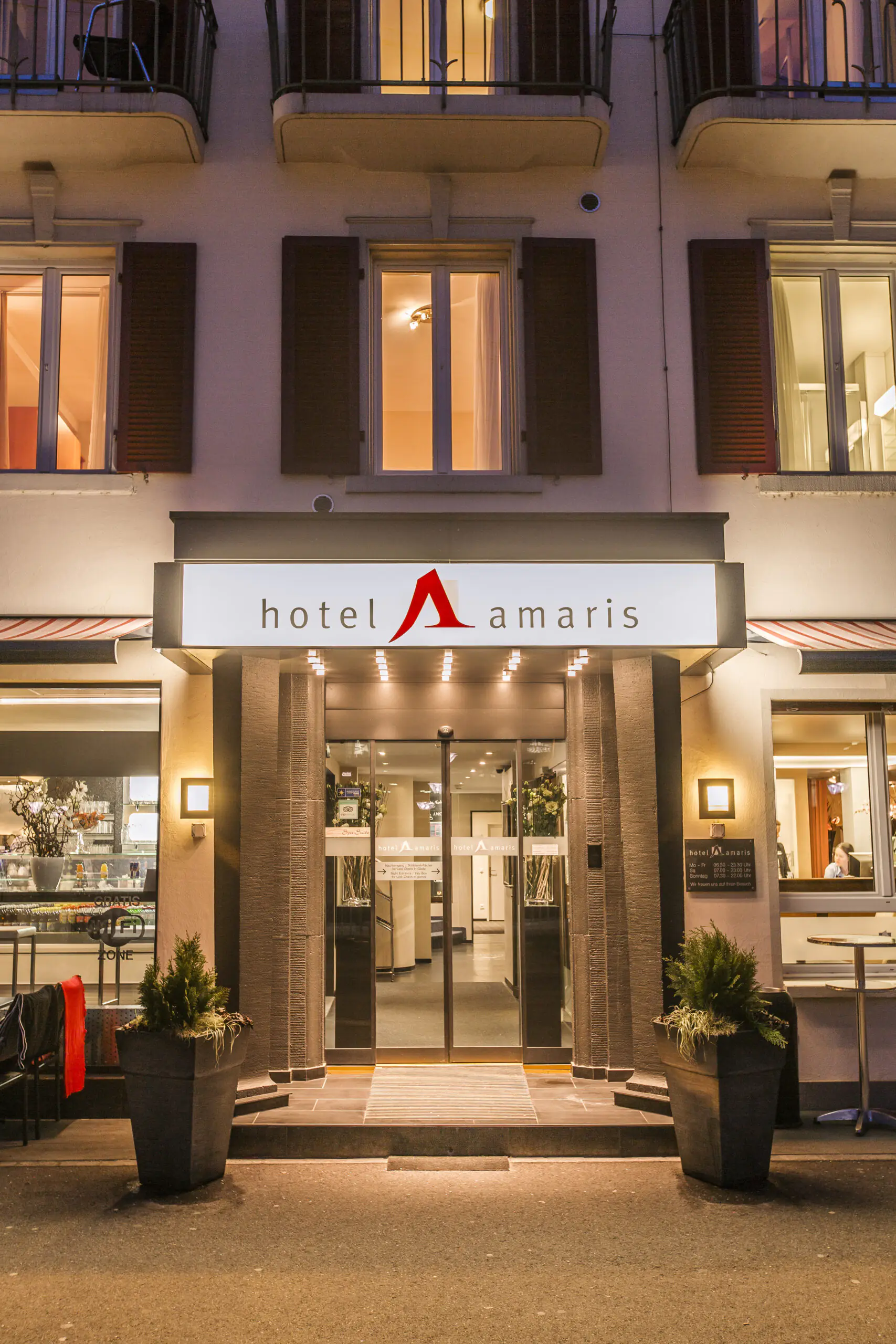 Beleuchteter Eingangsbereich des Hotel Amaris am Abend.